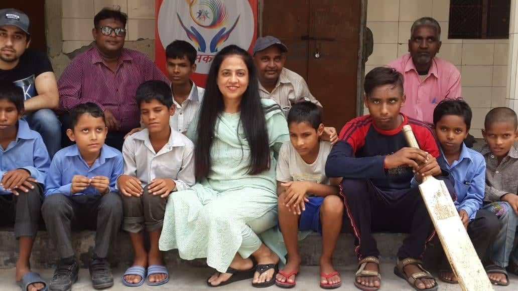 Shubhkarman volunteers seated with a group of children in Delhi